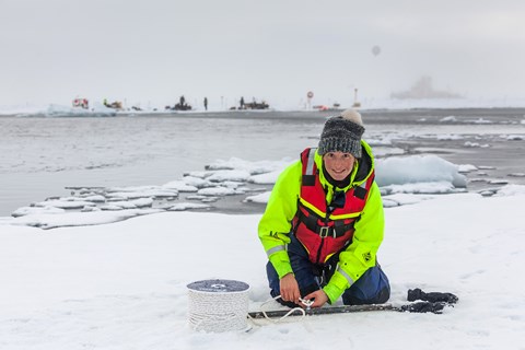 Helen Czerski setting an ice anchor on one of the floes on the other side of the open lead
