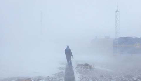 A person walks with his back to the camera back to the station. 