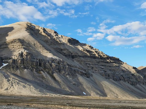 Ett Marsliknande landskap på Svalbard. På bilden syns en brun slänt med intressanta avsatser/formationer.