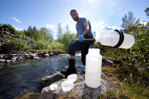 Niklas Rakos takes water samples in Miellejohka as part of the station's regular measurements. Photo: Anna-Karin Landin