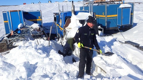 Stefan Gunnarsson and Ian Brown shovel away the snow from the tracked vehicle "gamla Bettan" 