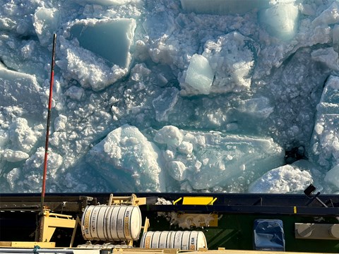 Stora flak av blå krossad is utanför Odens reling