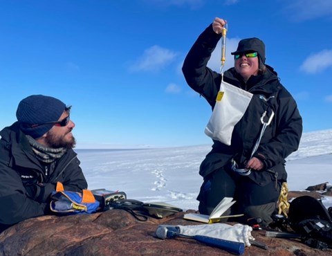 A white bag with rock samples is weighed.