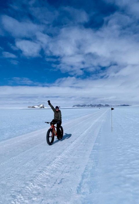 Person på en fat bike som ler och sträcker upp sin hand i luften.