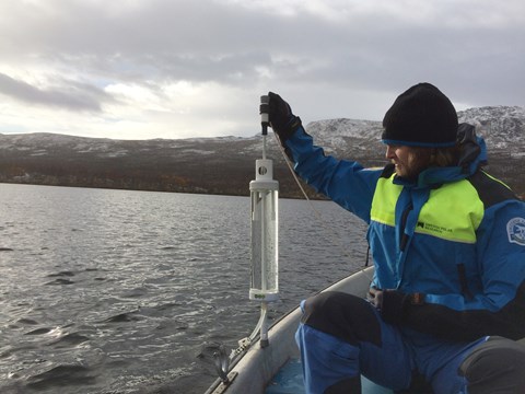 Erik Lundin takes a water sample in Almbergasjön