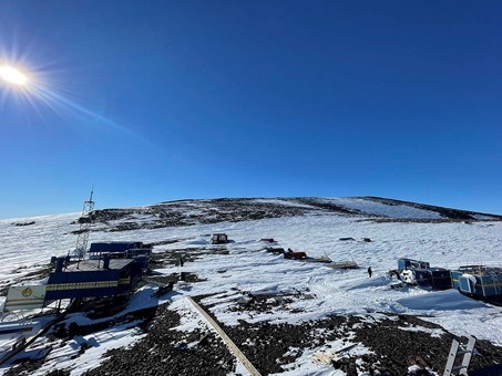 Vy från forskningsstationen Wasa: snö, bar mark, förrådscontainrar, blå himmel och solsken