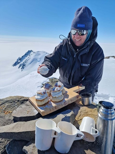 En kvinna lagar semlor utomhus. 