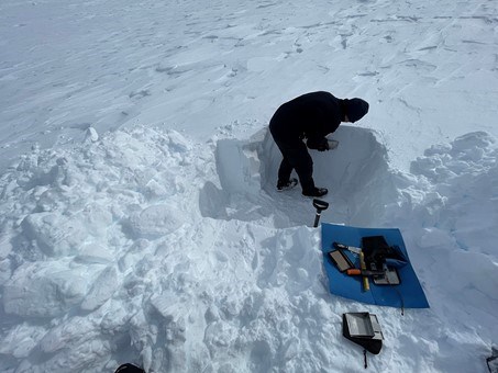 The researchers dig a pit in the snow to test instruments