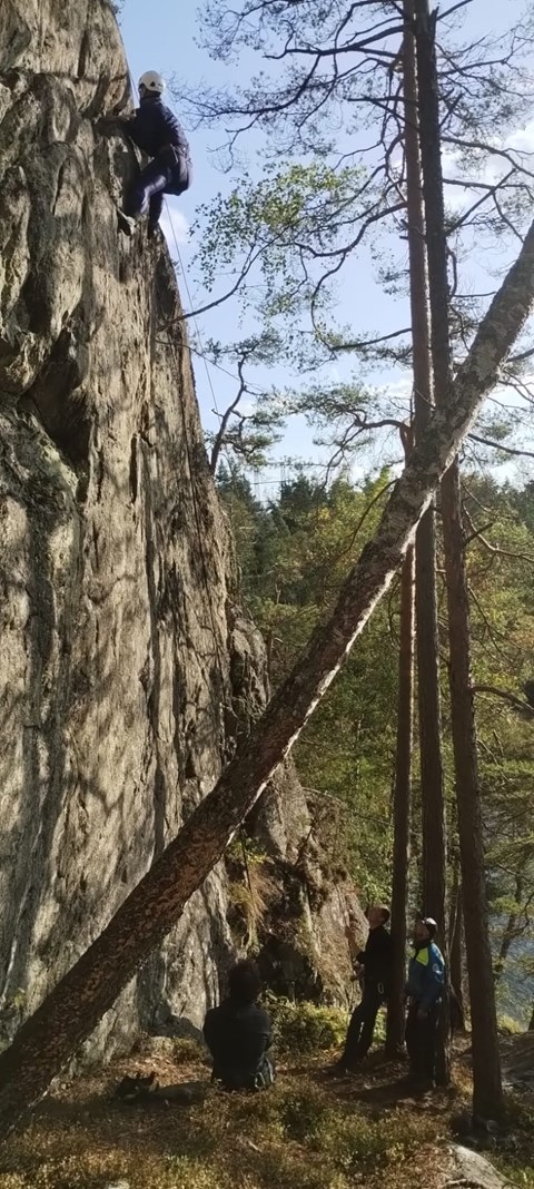  Person klättrar på bergsvägg.