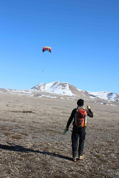 Person operates an airborne camera carried by a parachute.