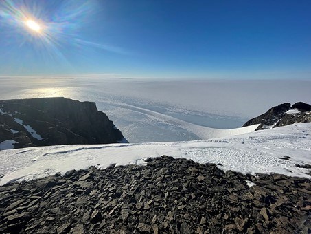 View from a peak behind Wasa. The sky is clear blue and the sun is shining.